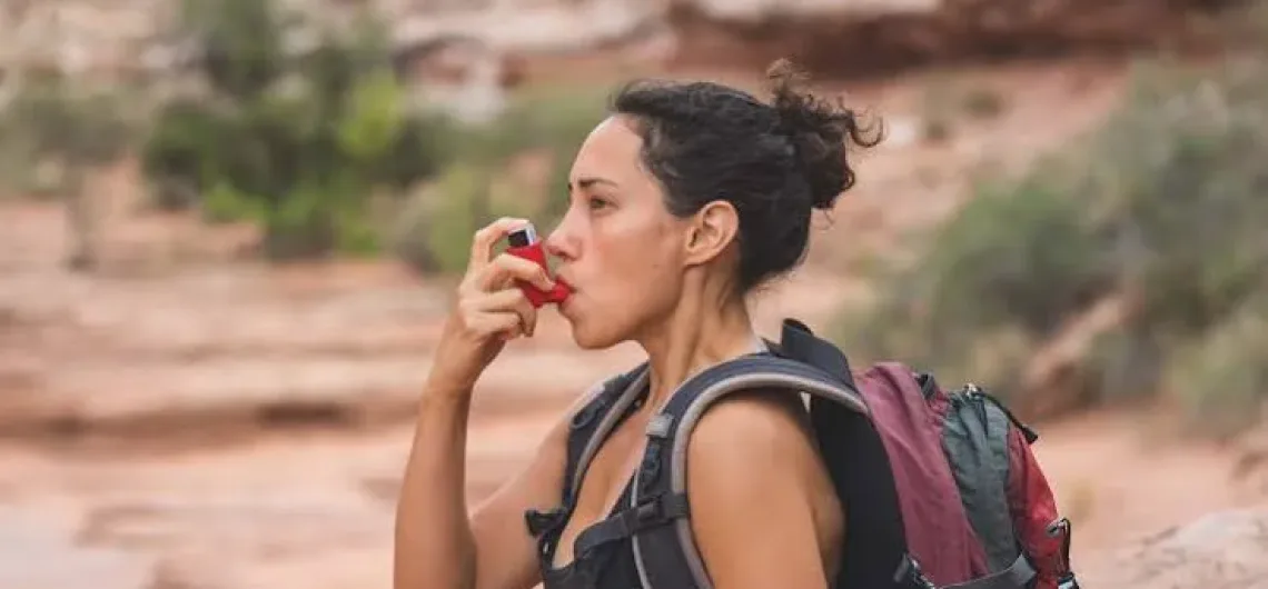climber using an inhaler on the mountain with asthma