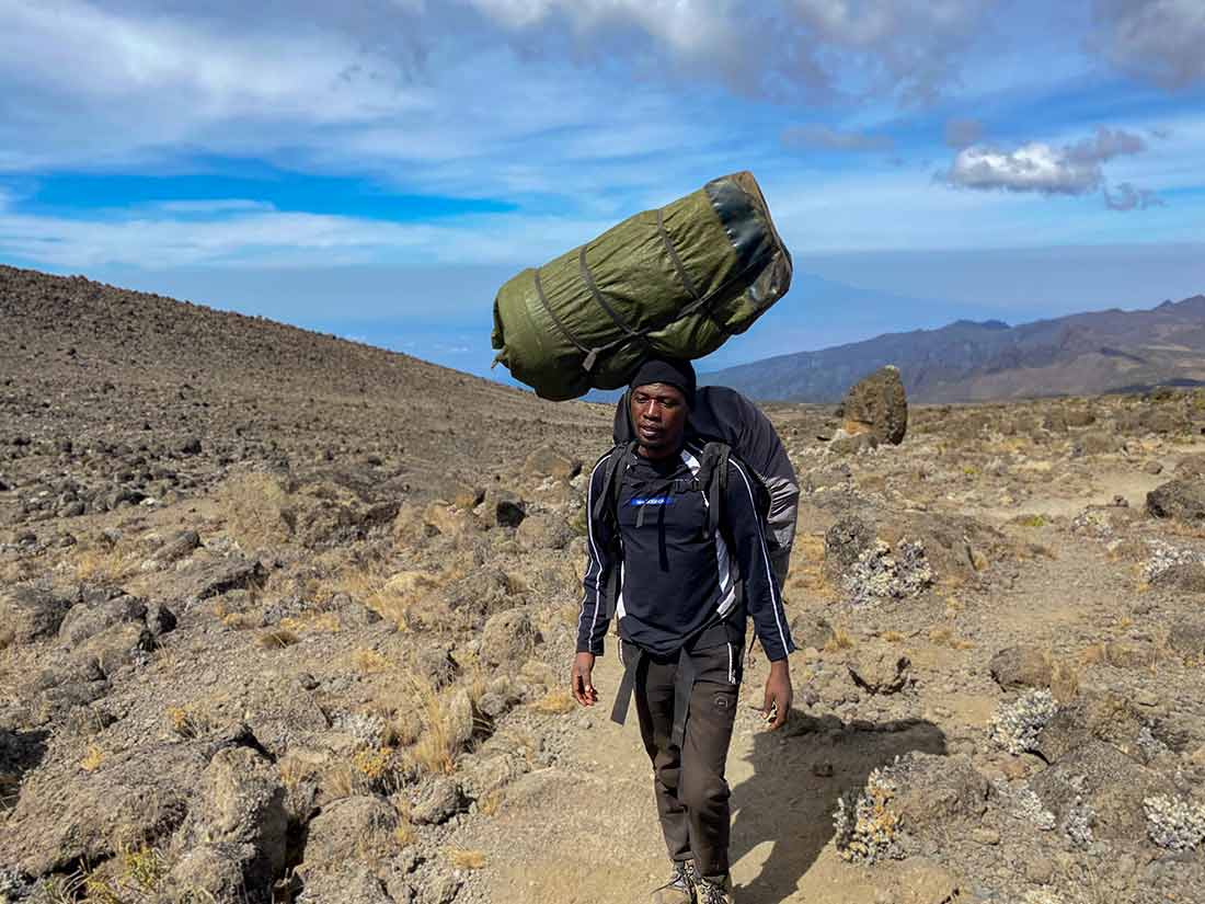 Porter carrying duffel bag